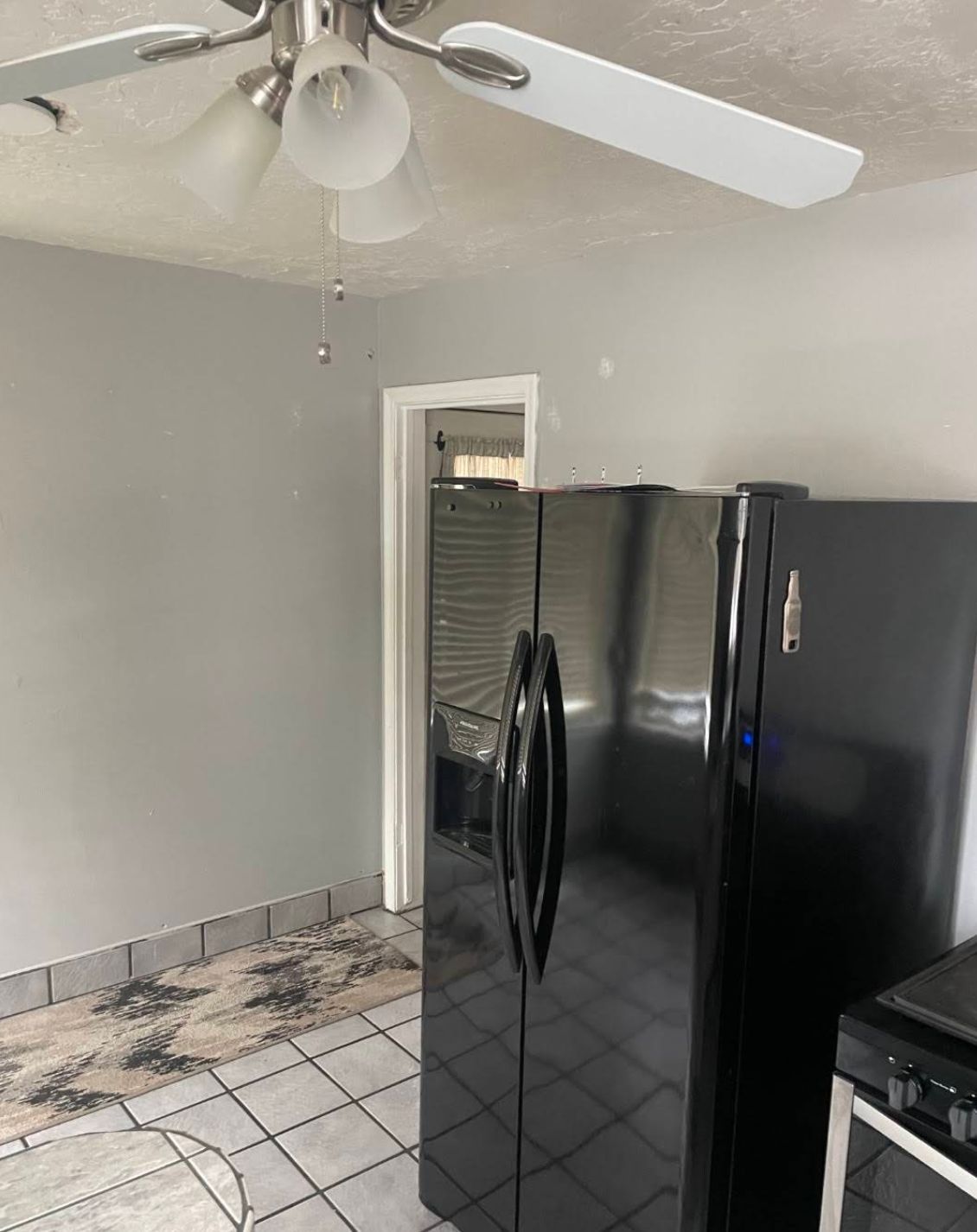 Outdated kitchen with gray tile countertops and old white cabinets before remodeling in Kaysville UT