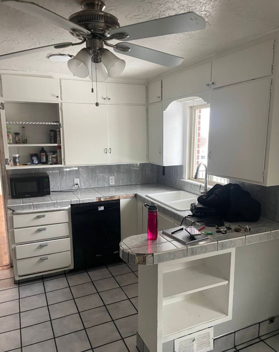 Living room showing hardwood floors and updated ceiling fan before full renovation