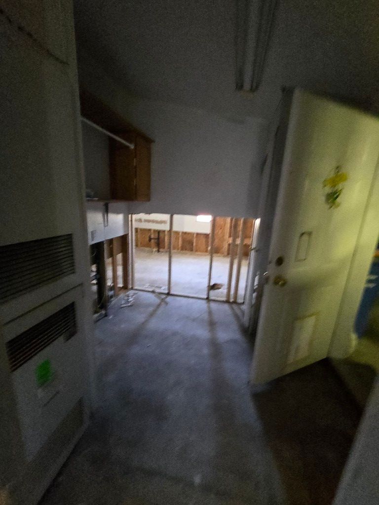 Demolished kitchen showing exposed subfloor and removed cabinets during water damage demo