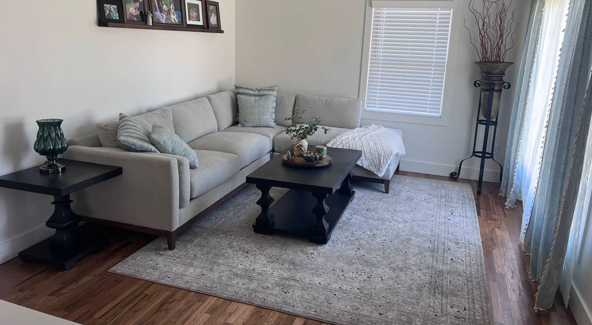 Renovated living room with sectional sofa and refinished hardwood floors after remodel