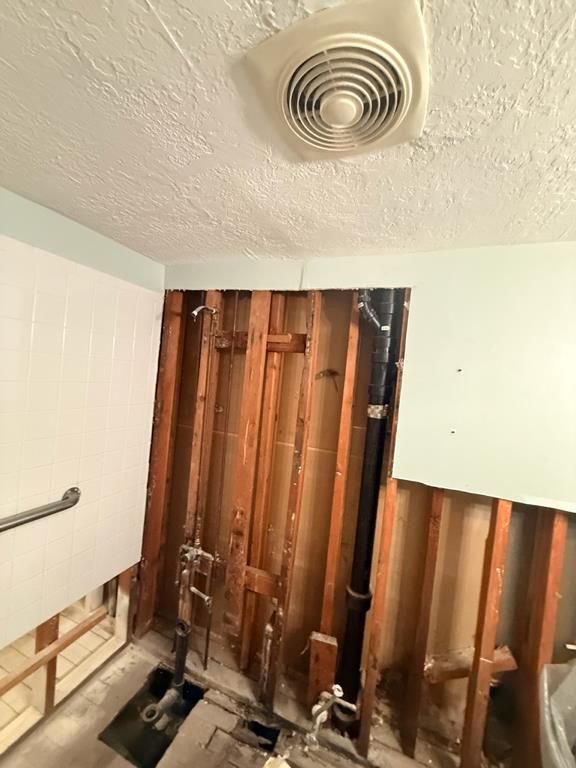 Hallway demolition with flood cuts on both walls and exposed subfloor during sewage restoration