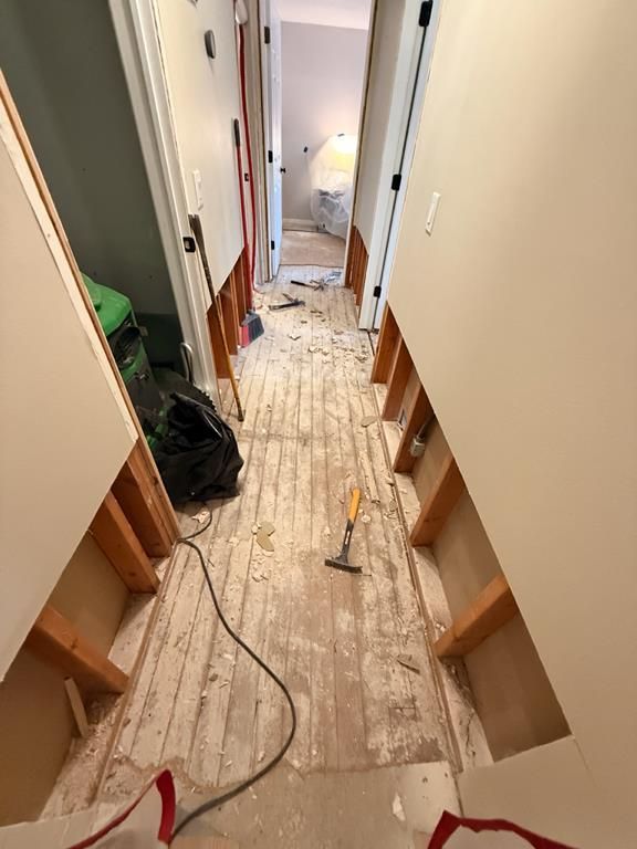 Bathroom drywall flood cuts exposing wall studs and plumbing behind tub wall