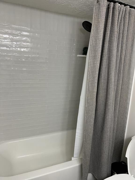 New subway tile tub surround with matte black fixtures after sewage damage restoration