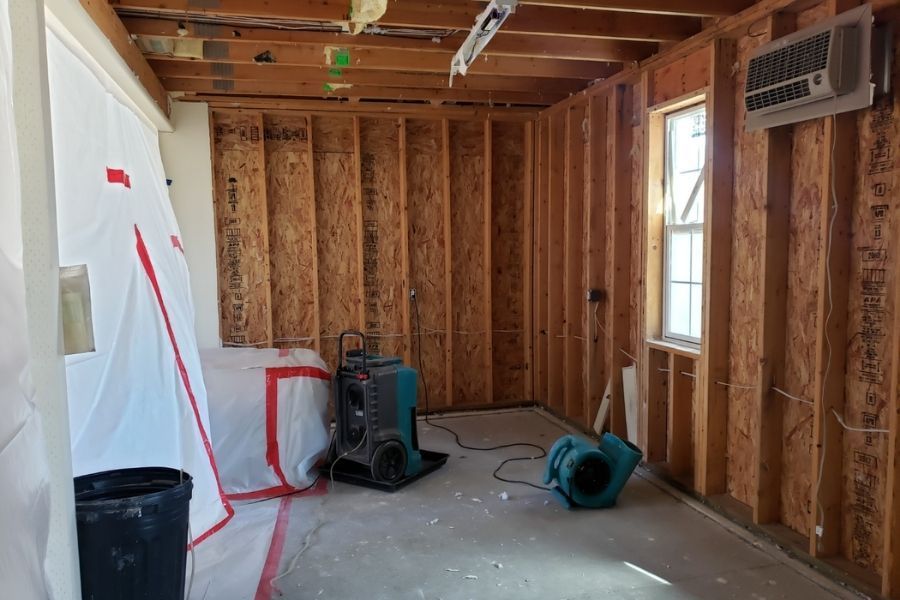 Commercial air movers and dehumidifiers set up during the water damage drying process