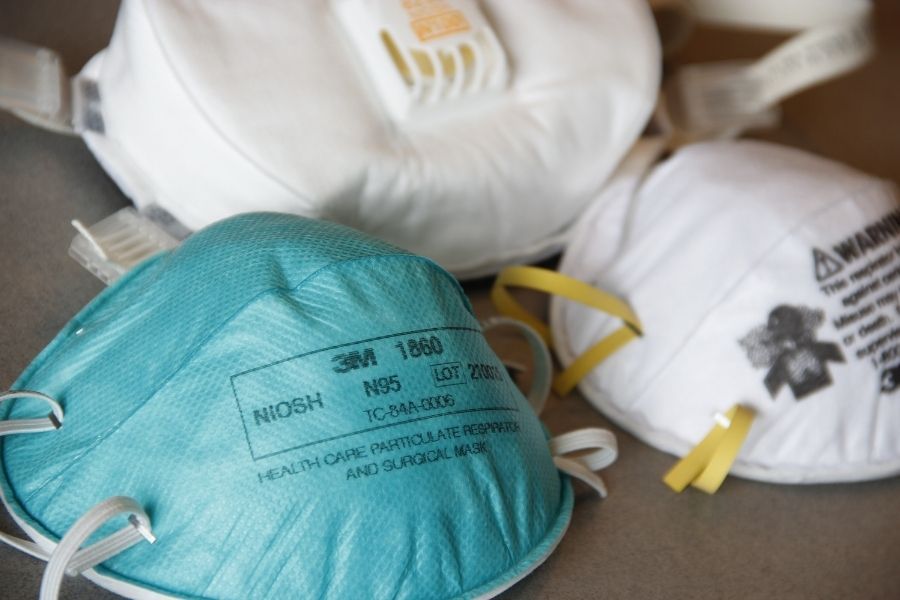 Person wearing an N95 respirator mask for protection when re-entering a fire-damaged home