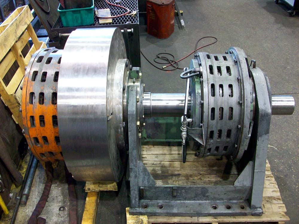 Industrial brake rotor assembly on a workbench, with large metal discs and perforated components.