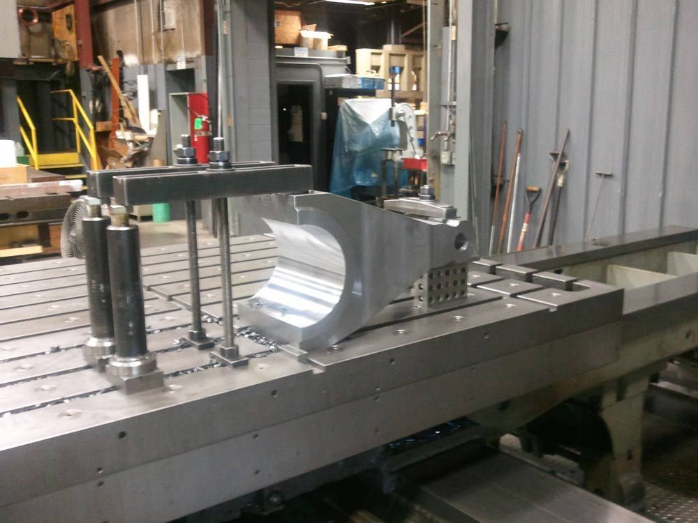 Industrial machine shop with a metal part clamped on a milling machine table
