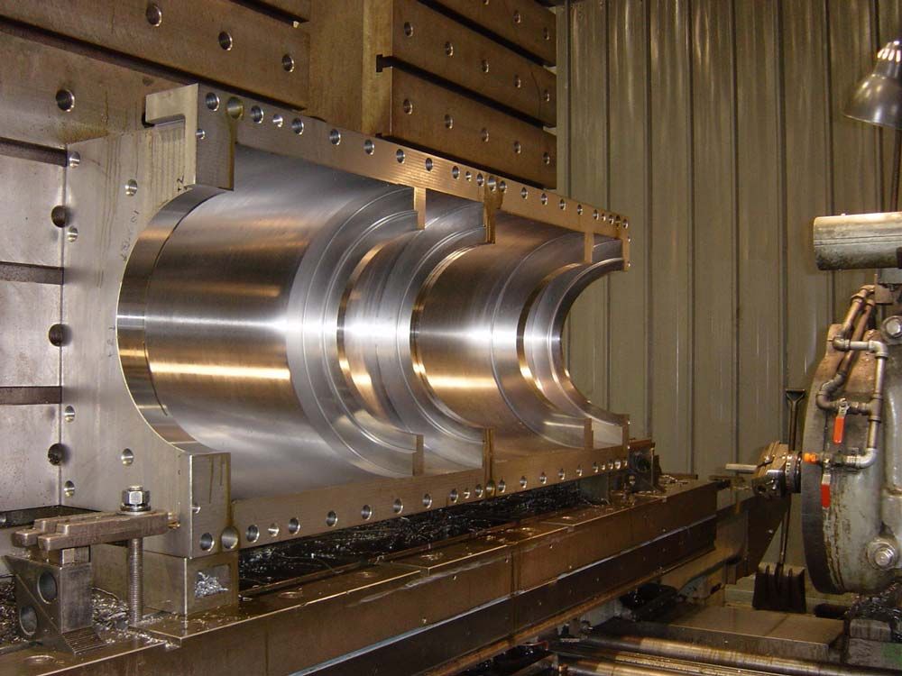 Large metal machining part mounted on a lathe in an industrial workshop