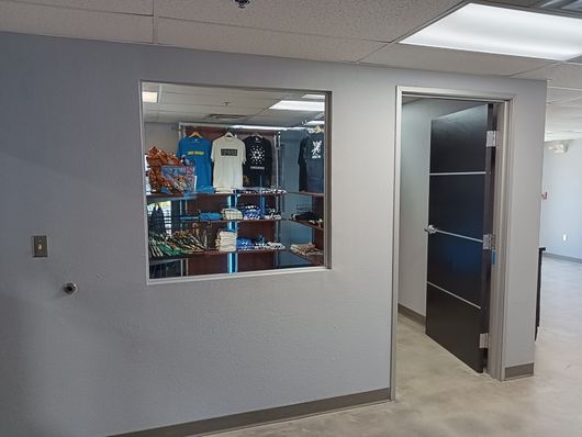 Retail store hallway with a display window and an open doorway to the right.