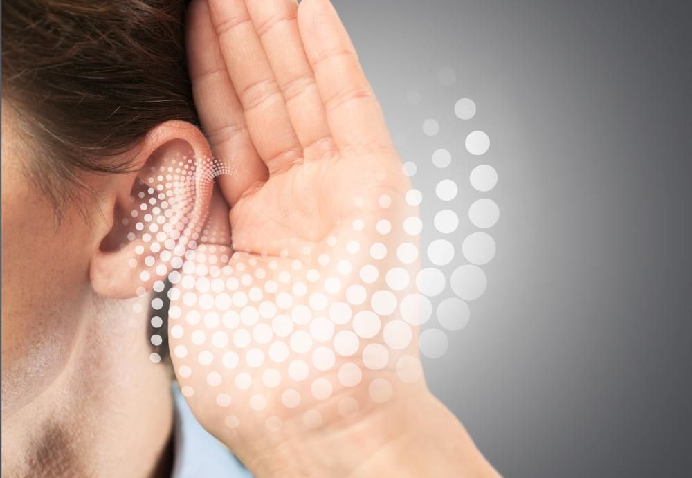 A Man is Holding His Hand to His Ear to Hear Something — Clayton Hearing in Pialba, QLD