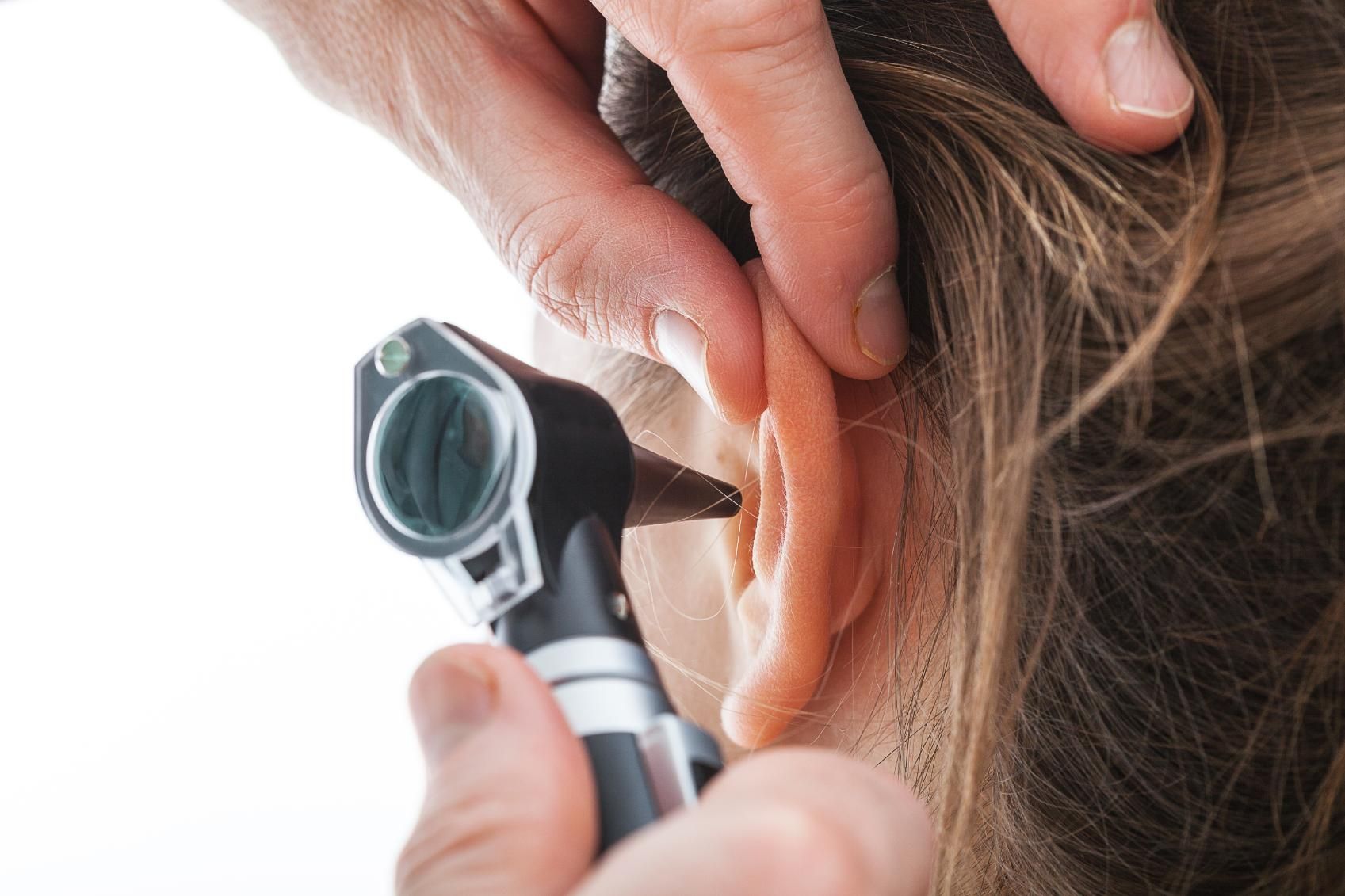 A Doctor is Examining a Woman 's Ear With an Otoscope — Clayton Hearing in Pialba, QLD