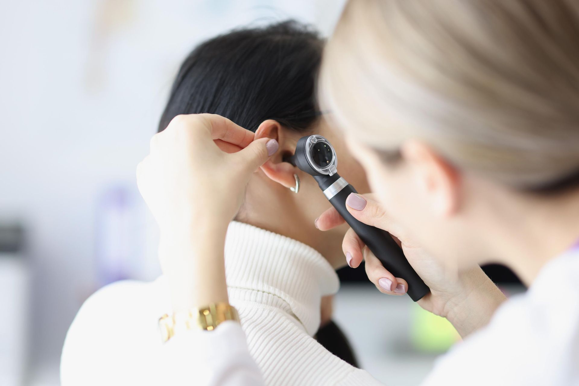 A Woman is Getting Her Ears Examined by a Doctor — Clayton Hearing in Pialba, QLD