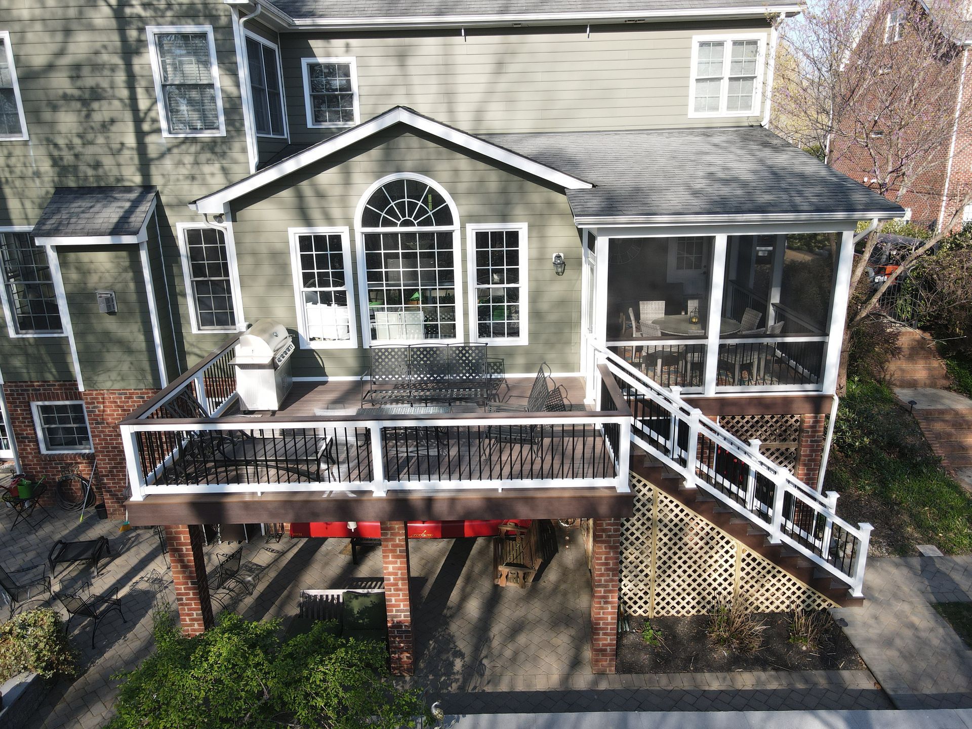 House exterior with a front porch, white railings, and stairs leading to the yard