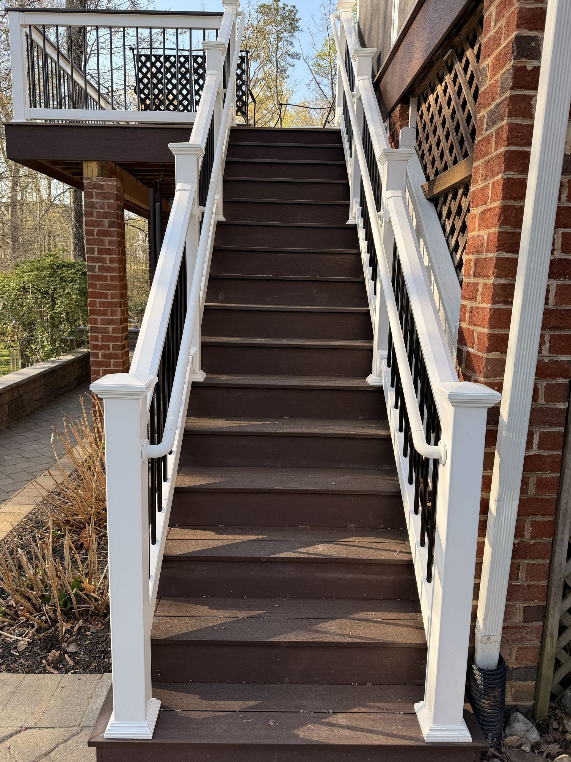 Exterior staircase with white railings leading up to a brick building entrance