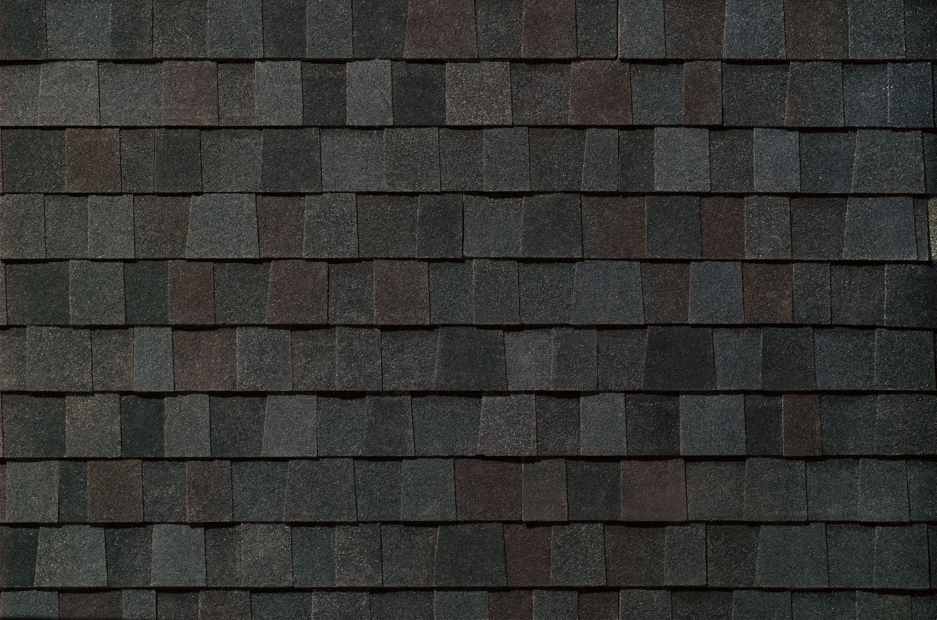 Close-up of dark gray roof shingles in a repeating horizontal pattern