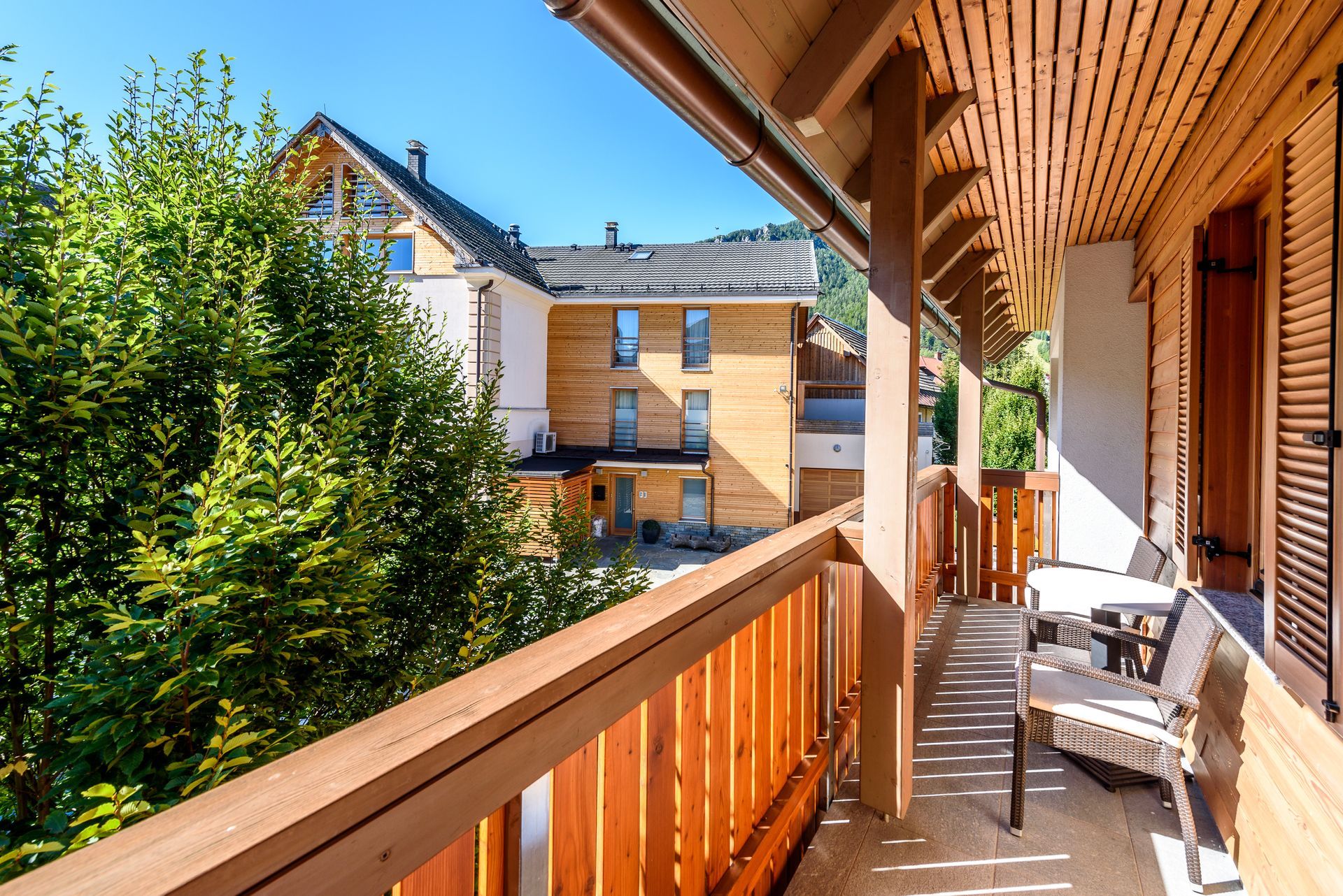 Deck with a wood railing and a tree in the background.