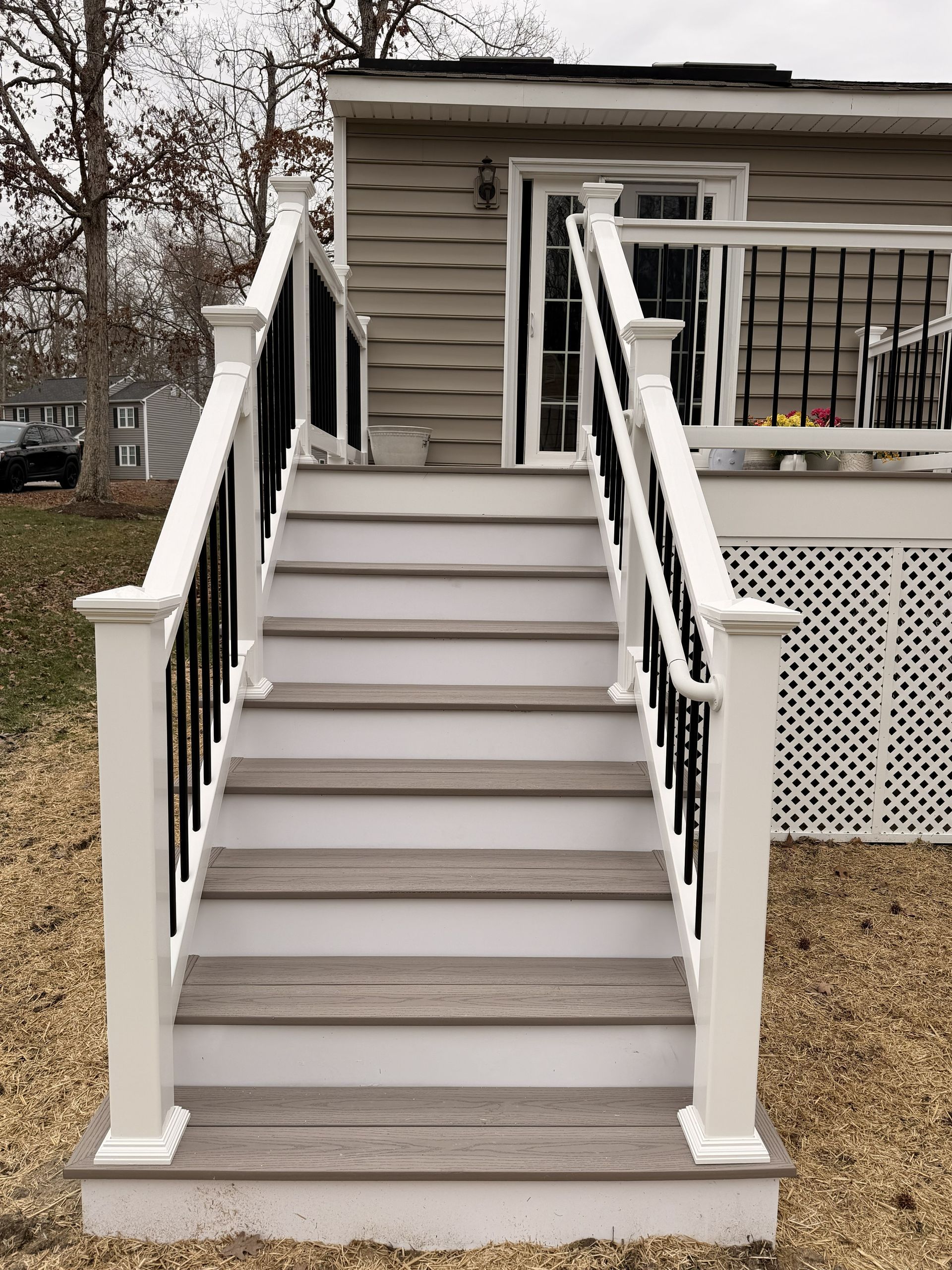 Front steps with white railings leading to a house porch with a screened section.