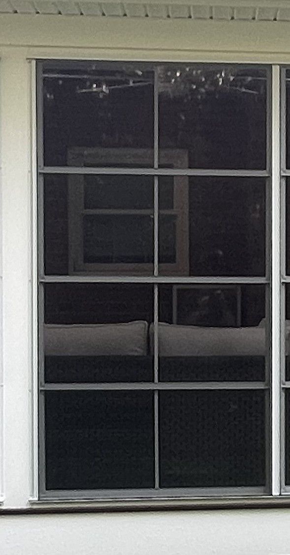 Window with white trim and dark reflected glass on a building exterior.