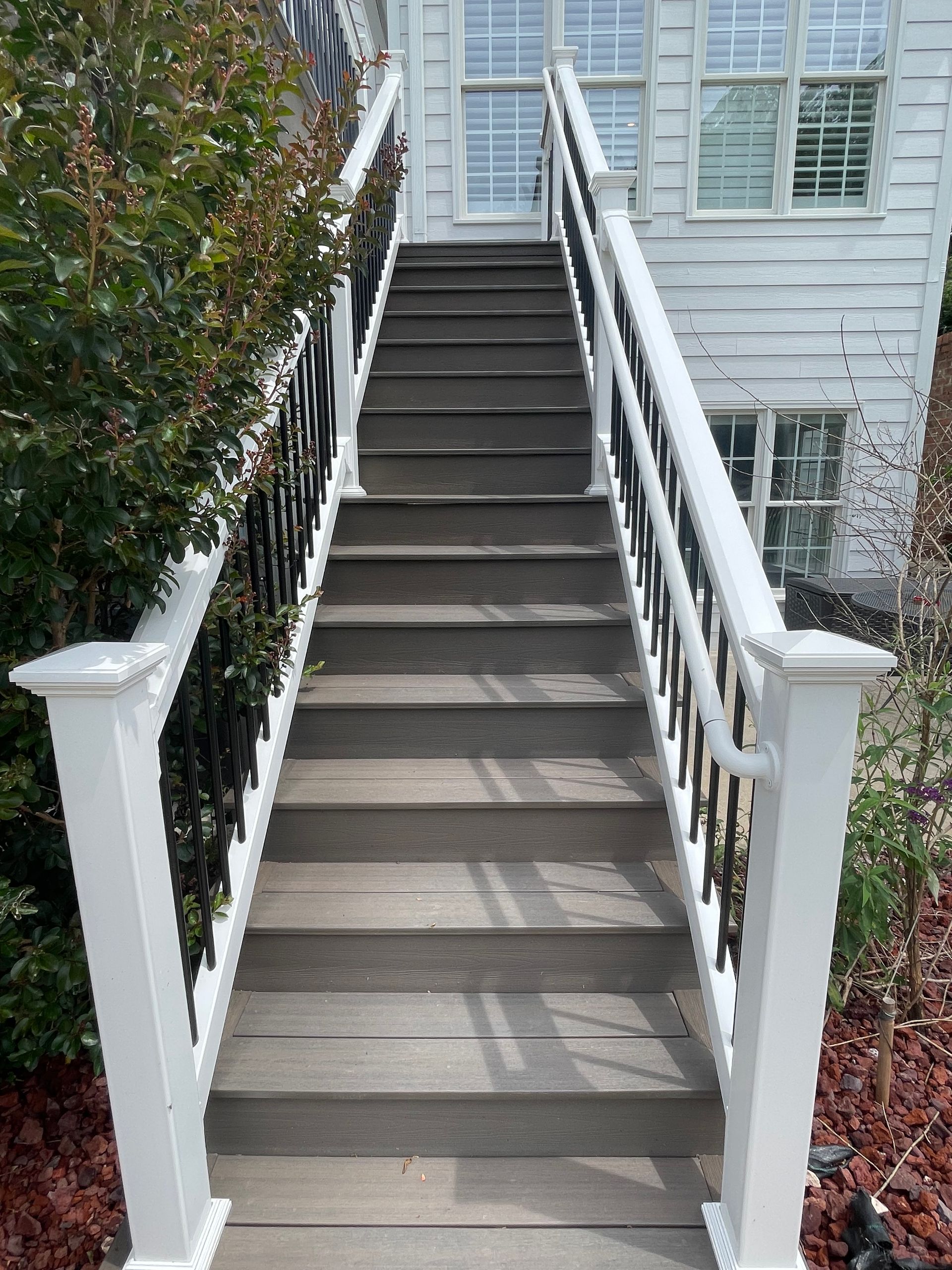 White outdoor staircase with railings leading up to a house entrance