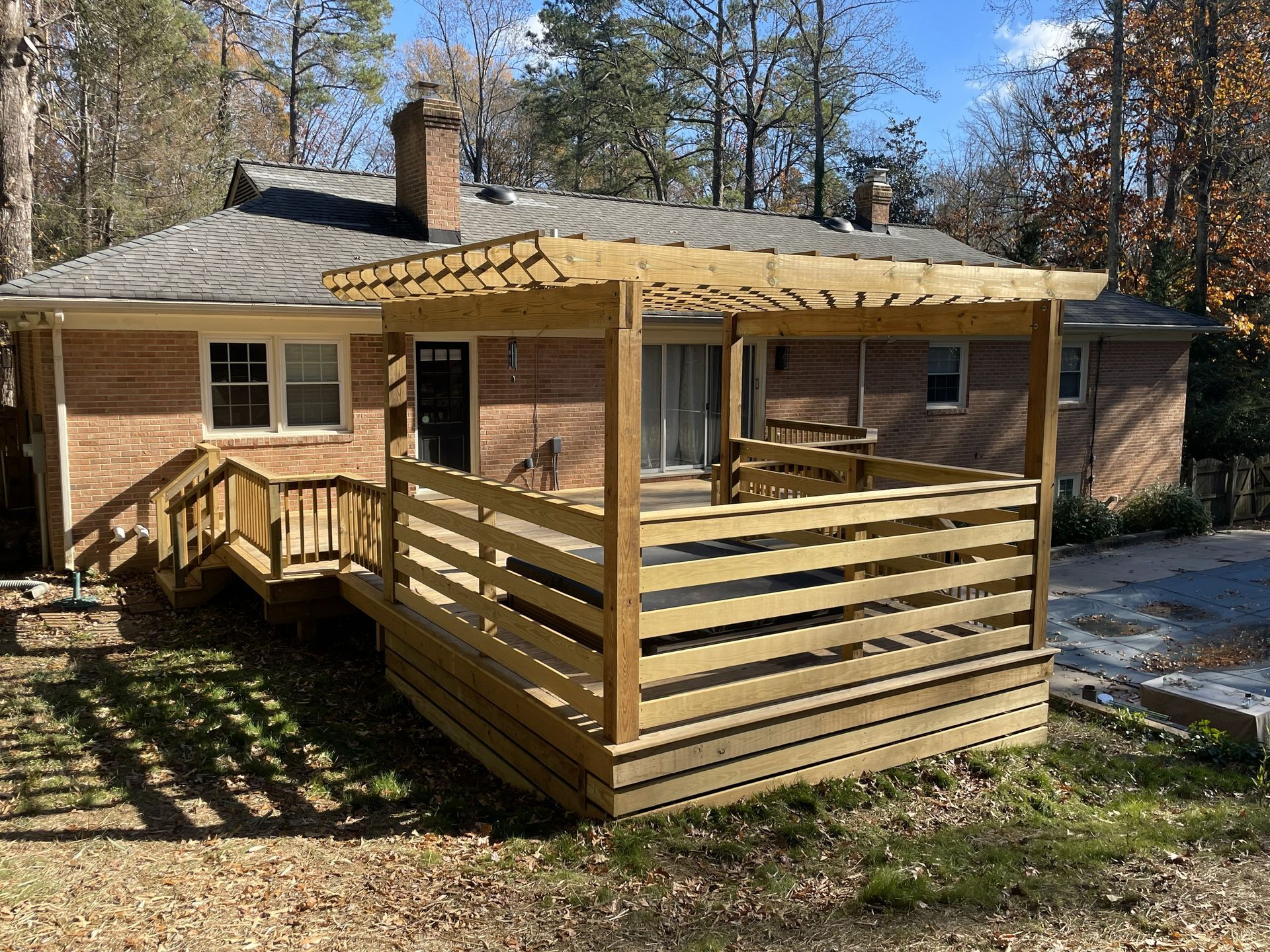 Wooden cabin porch with railings and a covered roof in a wooded yard
