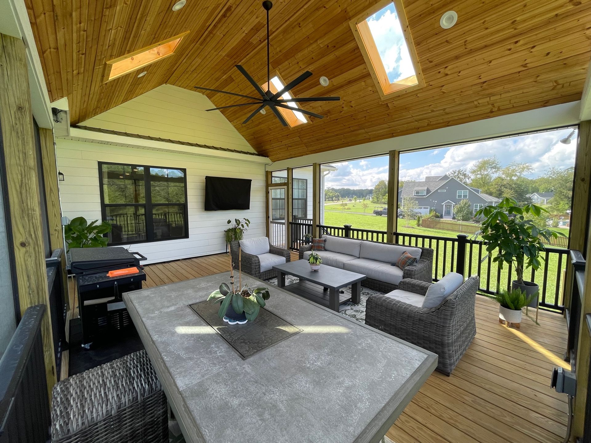 Covered outdoor patio with sectional seating, grill, ceiling fan, and mountain view