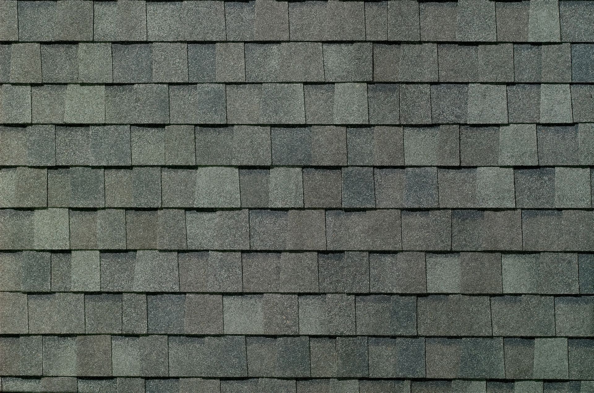 Gray asphalt roof shingles in a repeating horizontal pattern