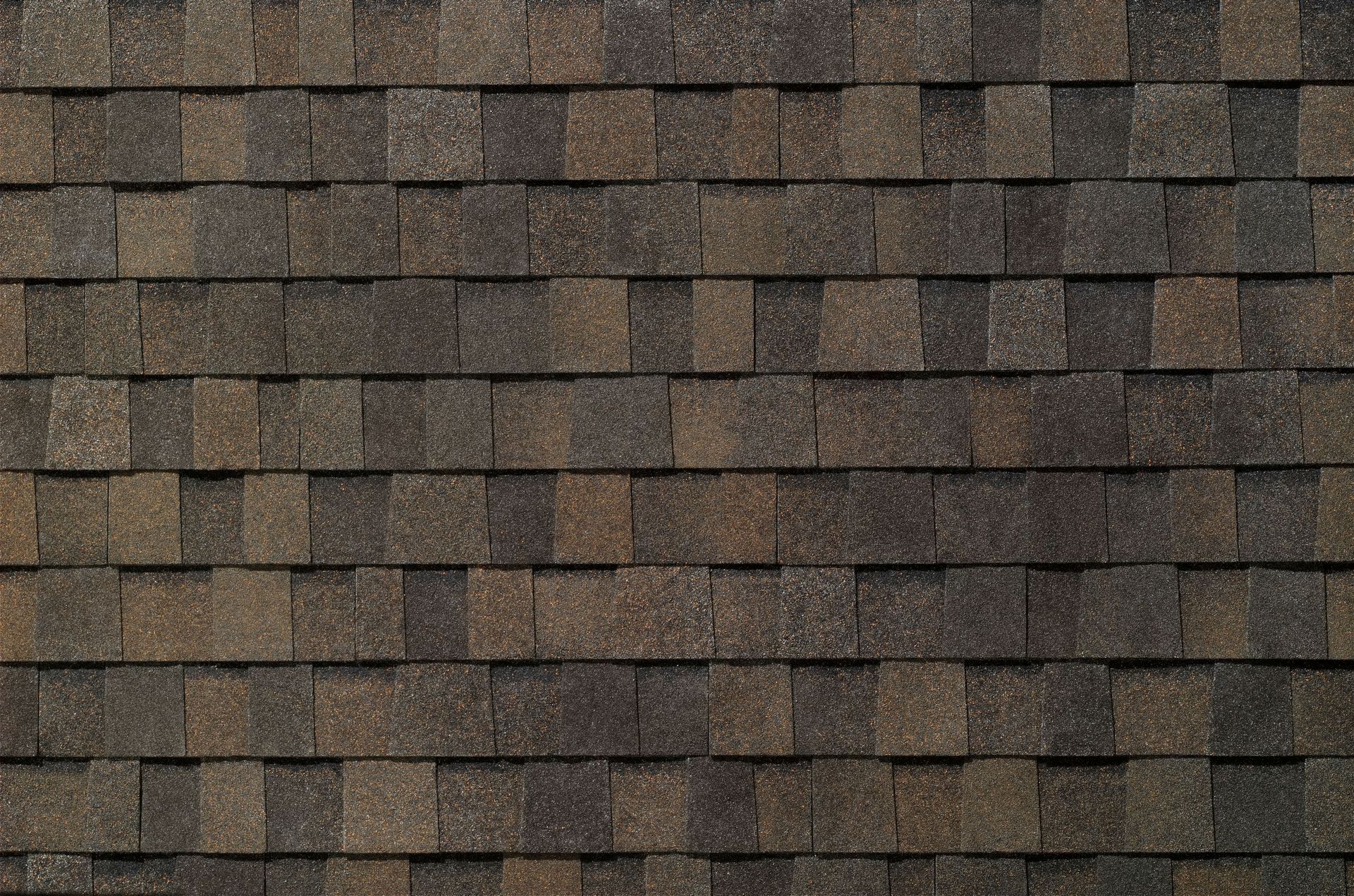 Close-up of brown roof shingles with a weathered, textured pattern
