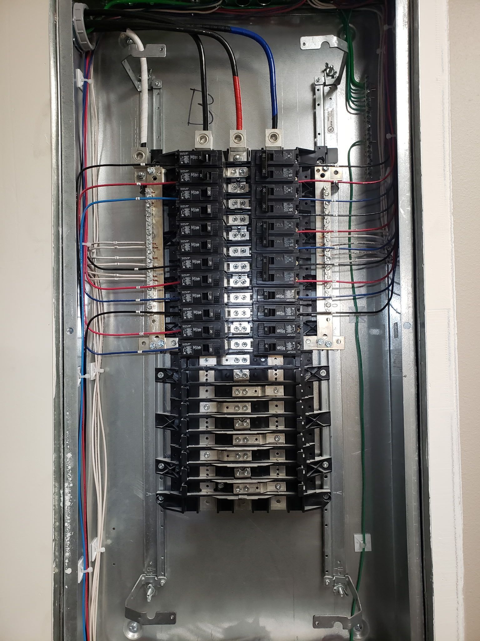 A close up of a electrical box with a lot of wires coming out of it.