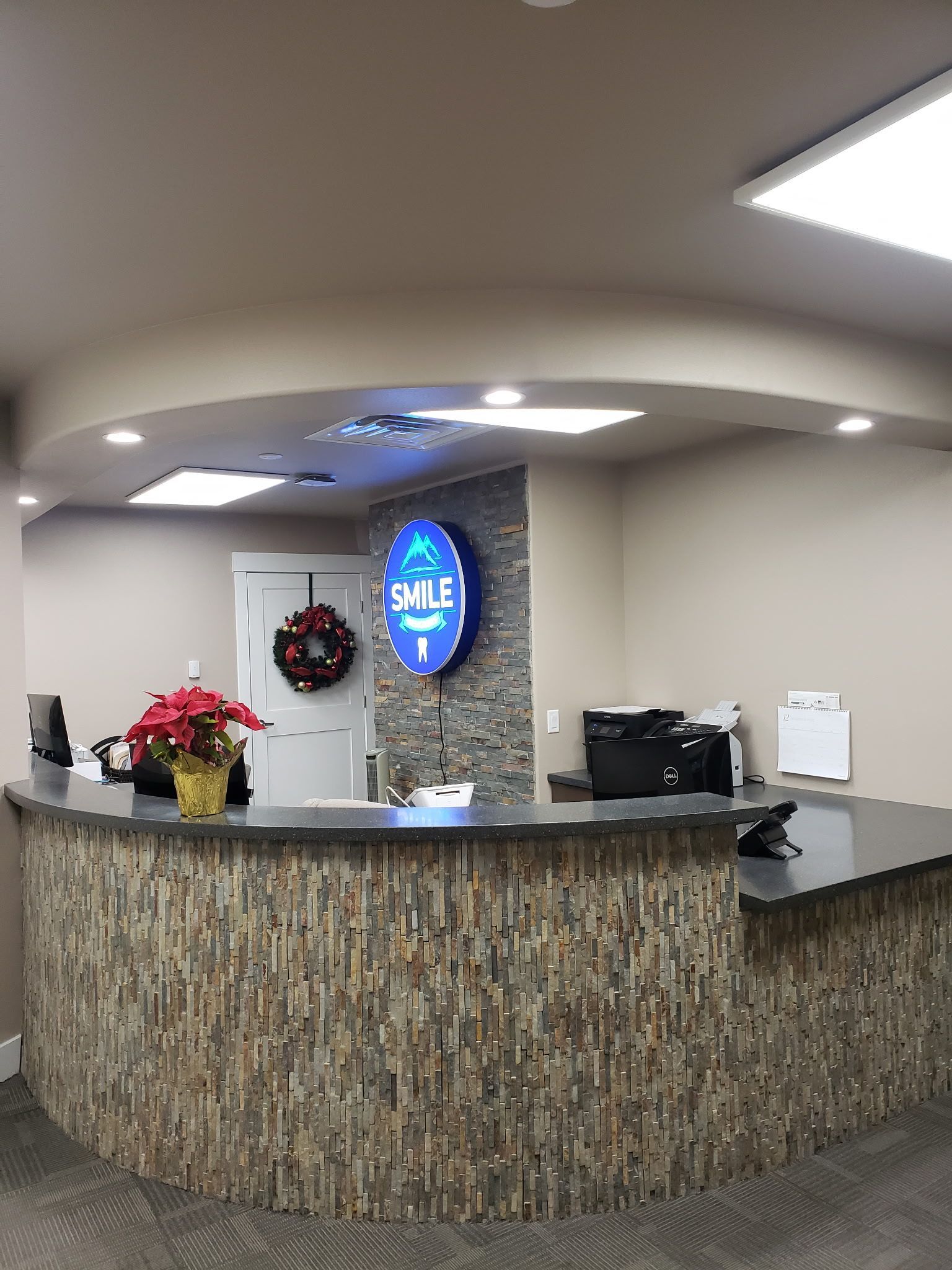 A dental office with a stone counter and a blue sign on the wall.