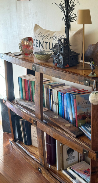 Wooden bookshelf with neatly arranged books and small decorative items in a cozy room