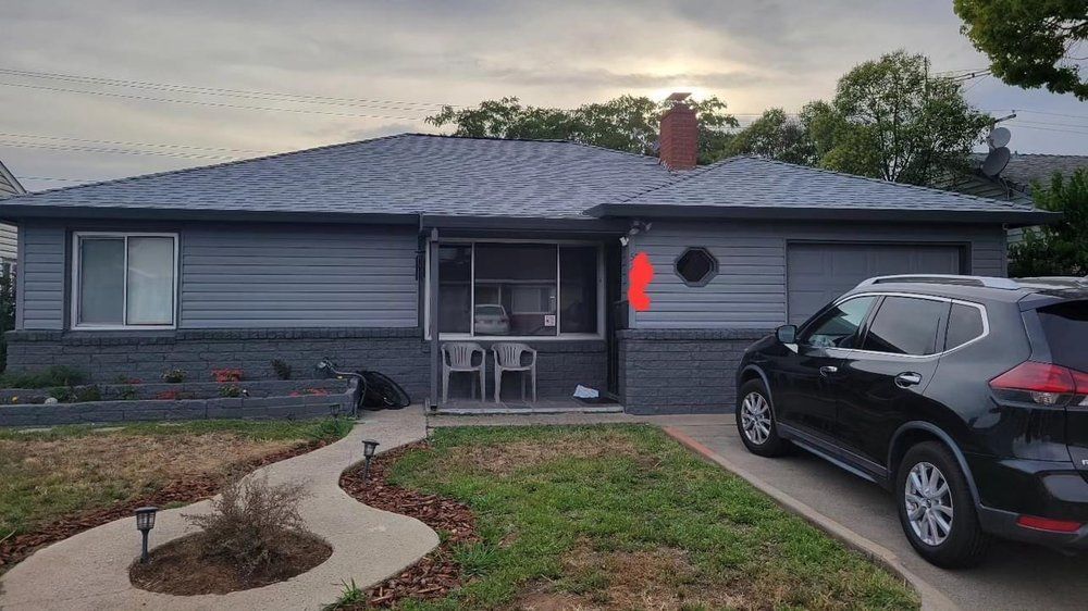 A black suv is parked in front of a house.
