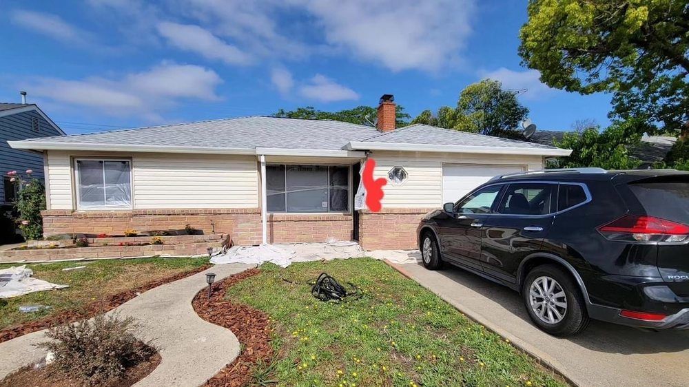 A black car is parked in front of a house.