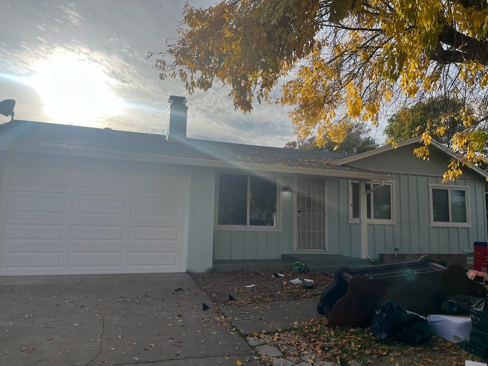 A house with a garage door and a chimney on the roof.