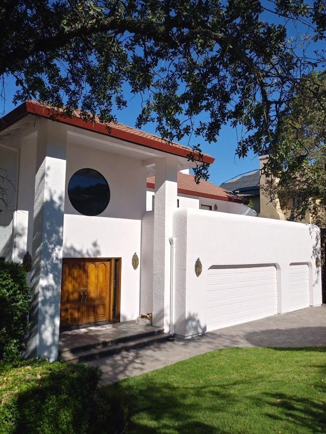 A white house with a red roof and a round window