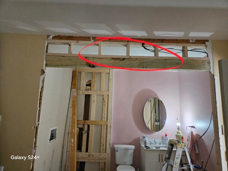 Partially demolished ceiling over a bathroom, with exposed framing circled in red.