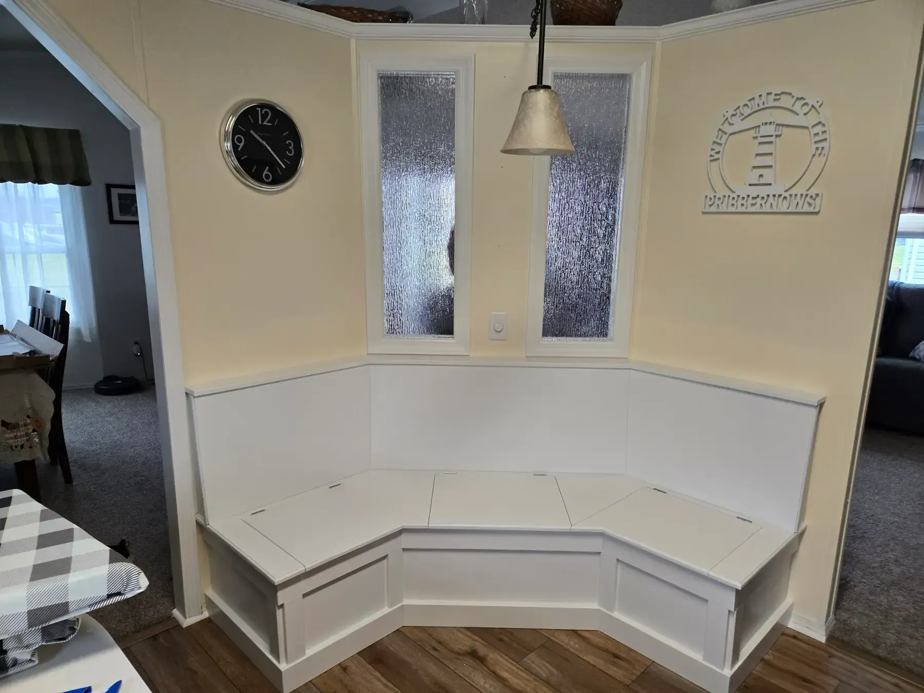 Built-in white corner bench with storage drawers in a bright kitchen nook