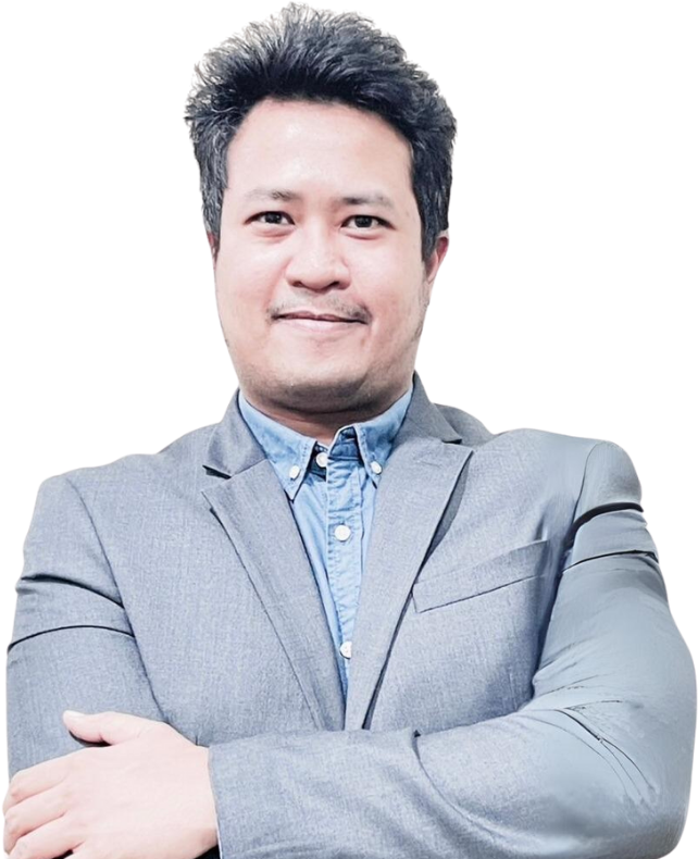 A man in a suit and blue shirt is standing with his arms crossed.