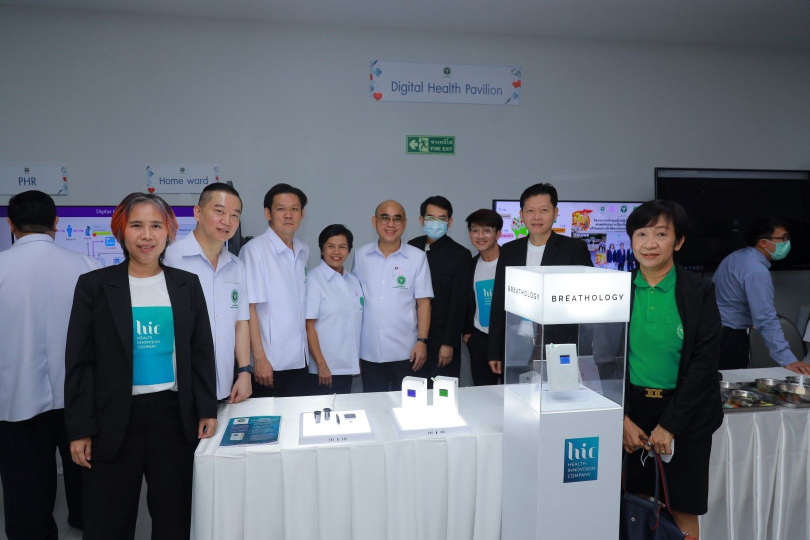 A group of people are standing around a table in a room.