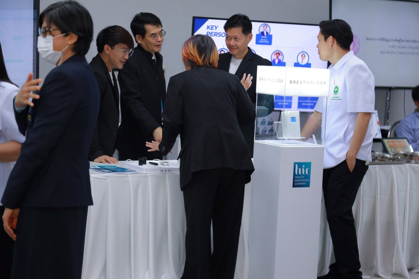 A group of people are standing around a table in a room.