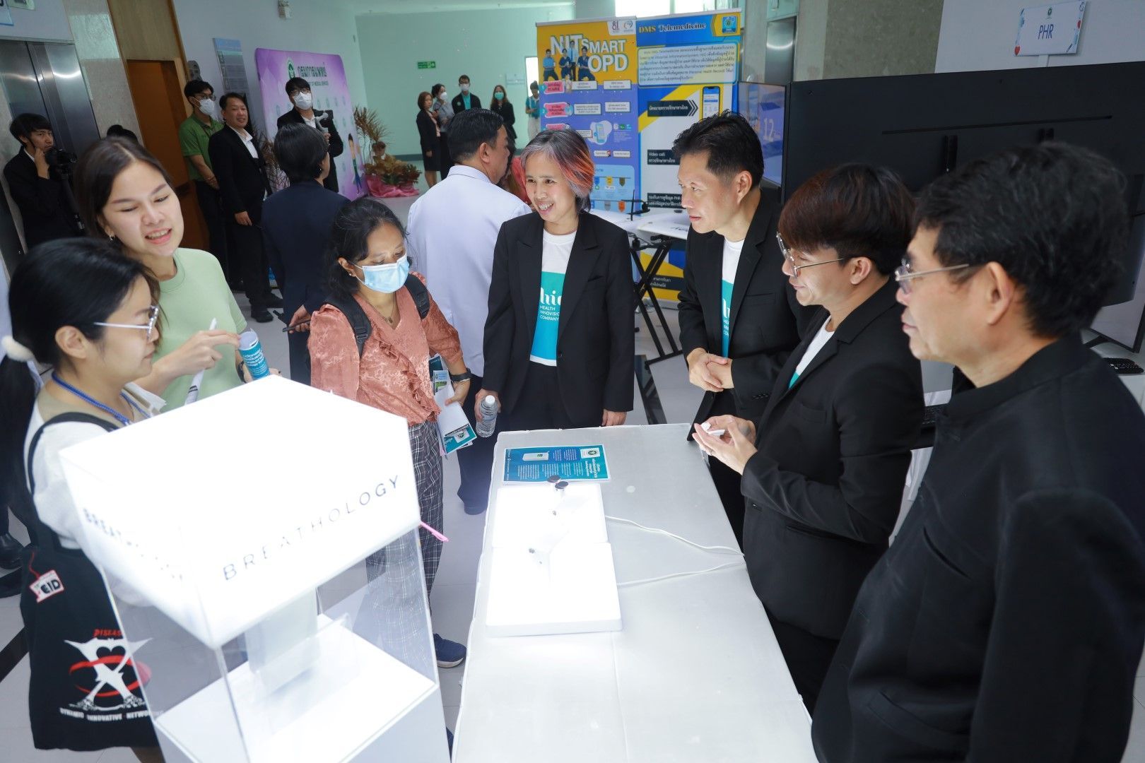 A group of people are standing around a table looking at a display.