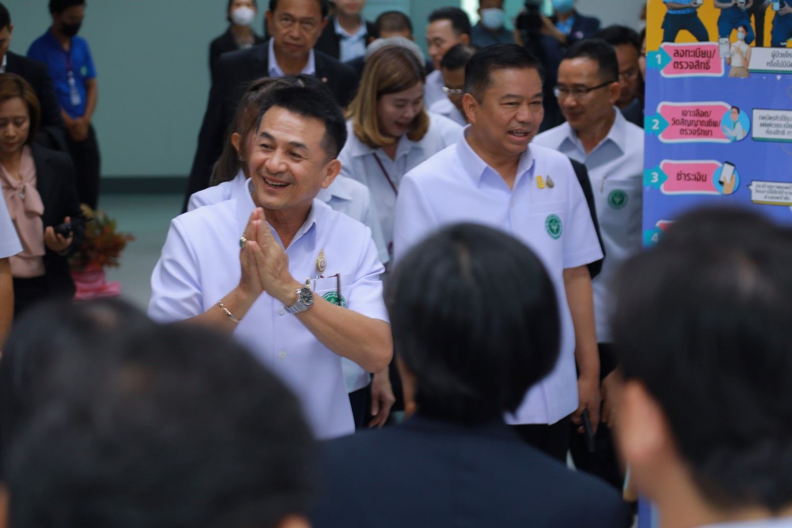 A group of men in white shirts are standing in a room.