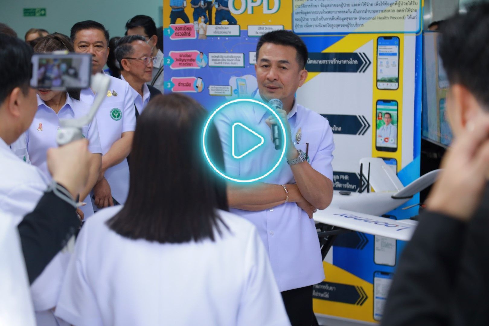 A man in a white shirt is talking to a group of people