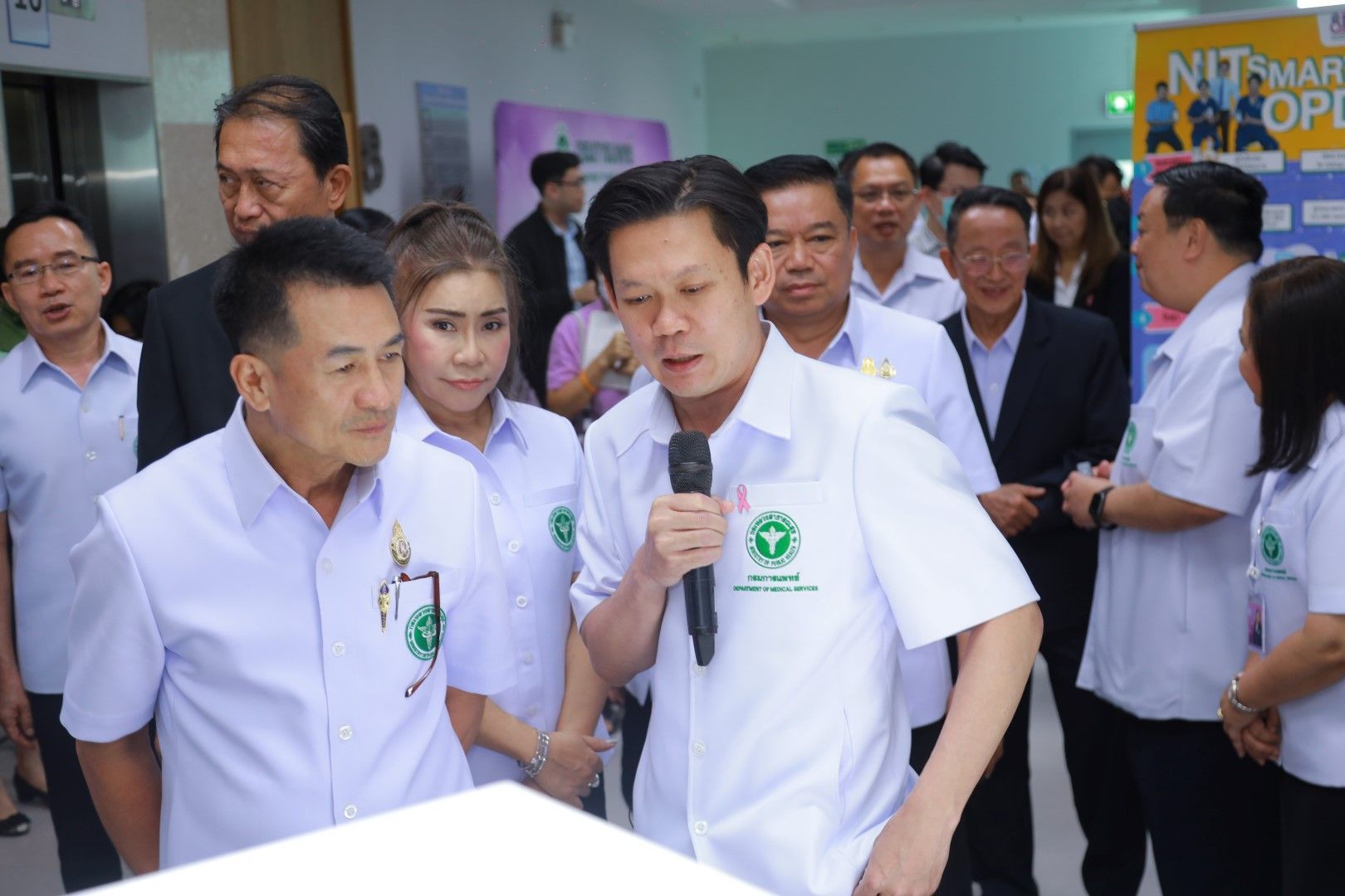 A group of people are standing around a man holding a microphone.