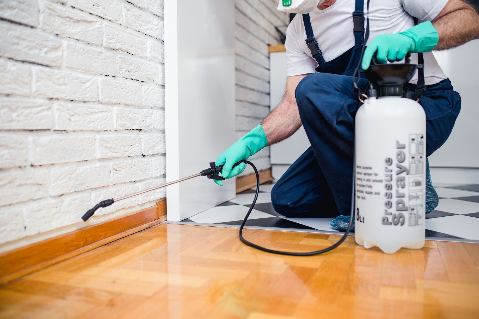 An exterminator is spraying pesticide.