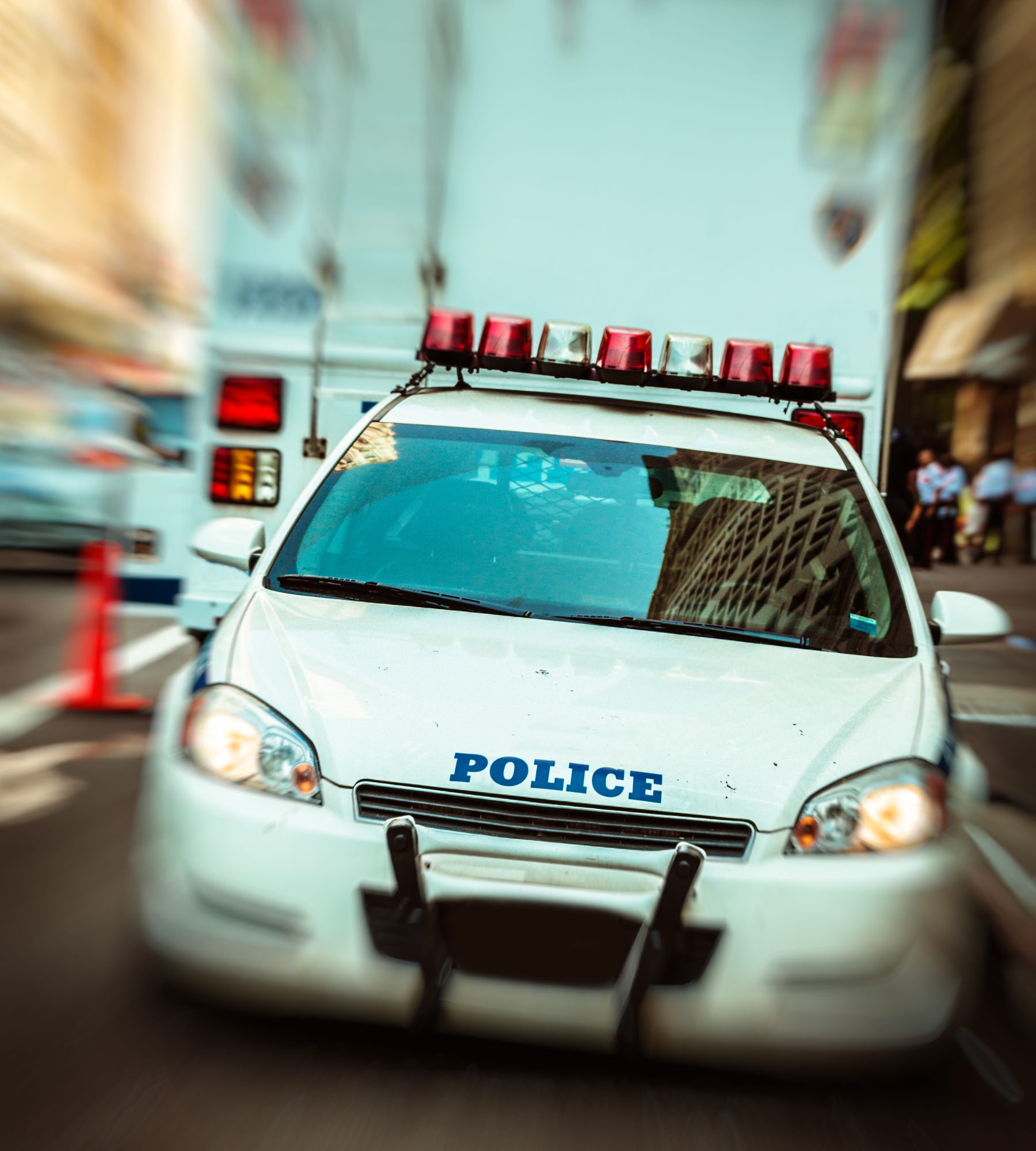 A white police car is driving down the street