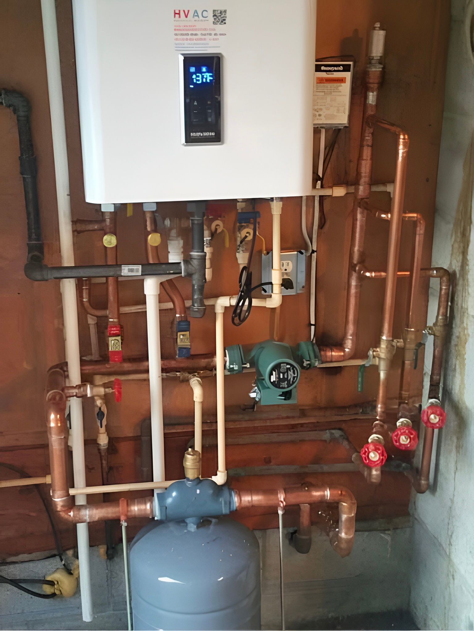 Wall-mounted boiler and copper pipes in a utility room with a gray expansion tank and red valves.