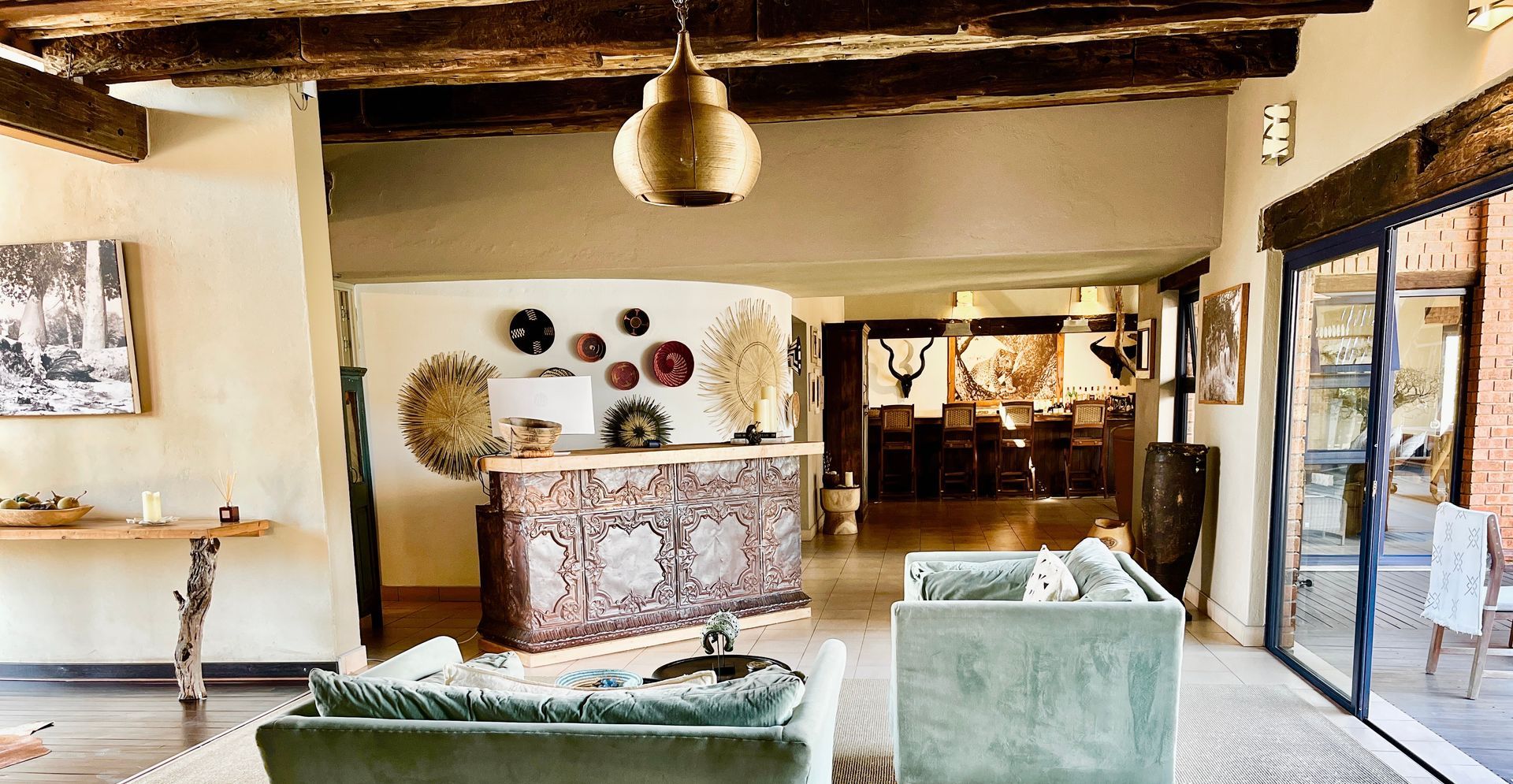 Modern hotel lobby with rustic beams, vintage decor, and green sofas