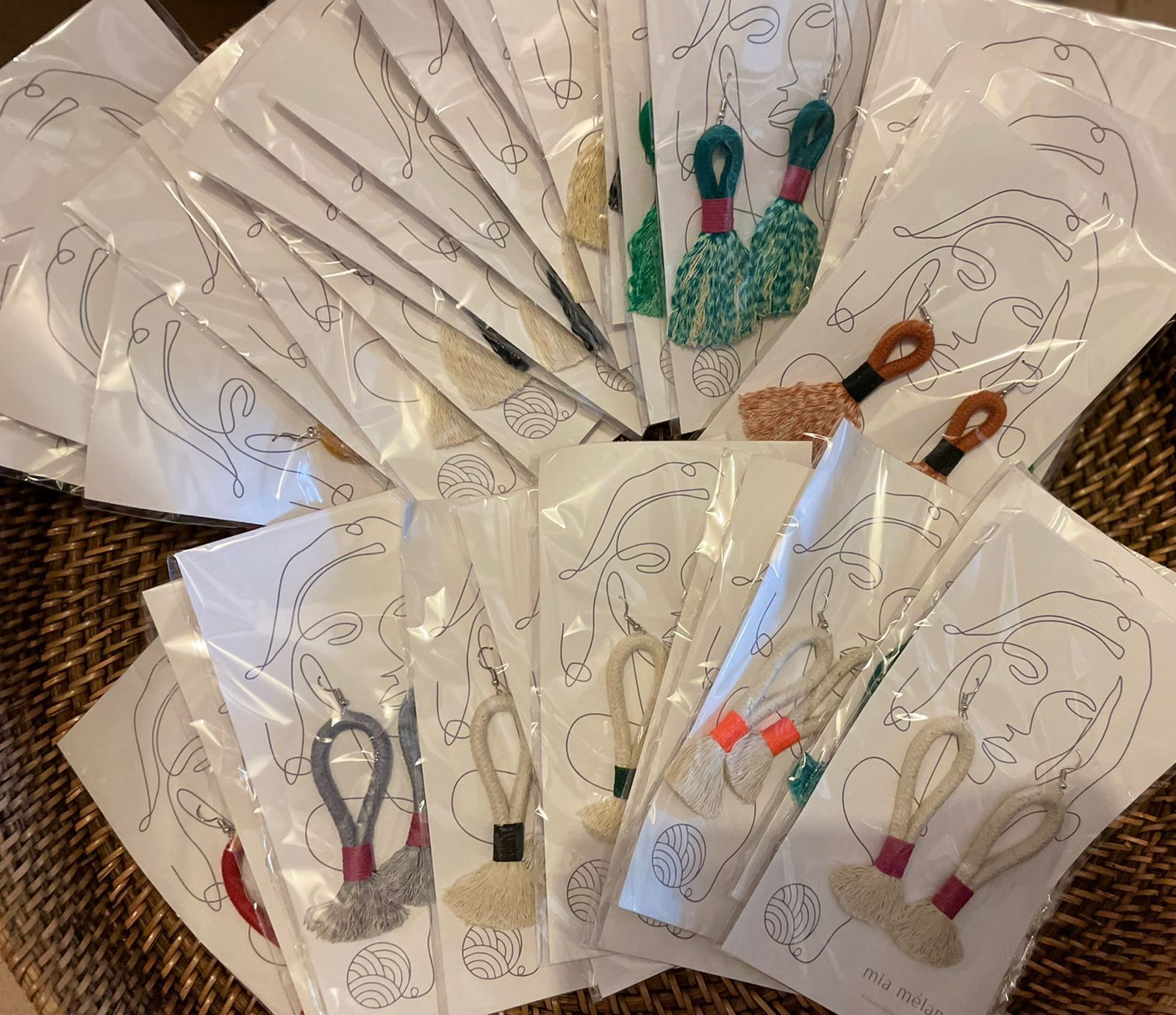 Fan of floral-themed craft scissors in clear packaging on a woven surface