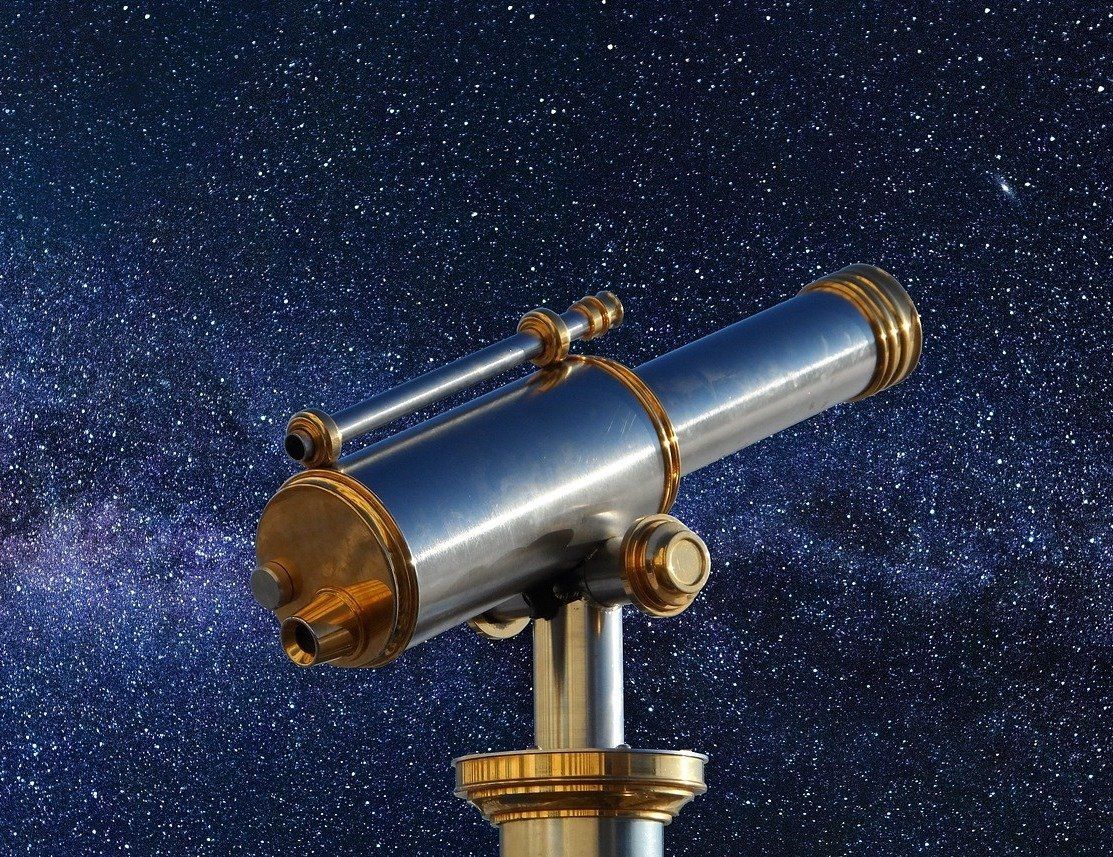 Brass telescope against a starry night sky