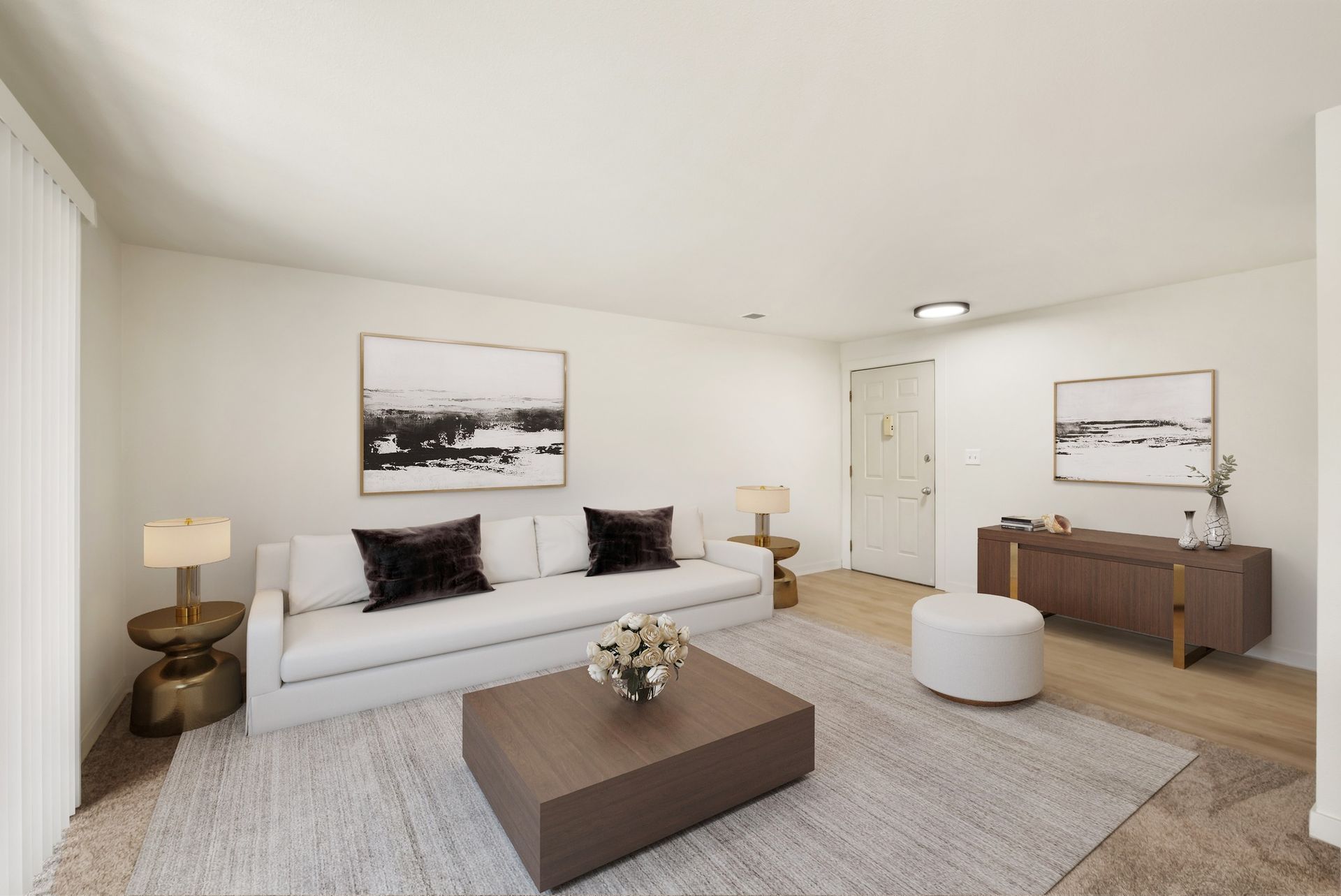 Bright minimalist living room with white sofa, coffee table, rug, wall art, and sideboard